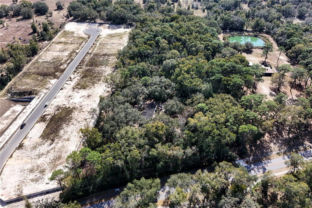 An aerial view shows a paved road, a cleared lot, and a wooded area — 344 W PONKAN ROAD, APOPKA, FL