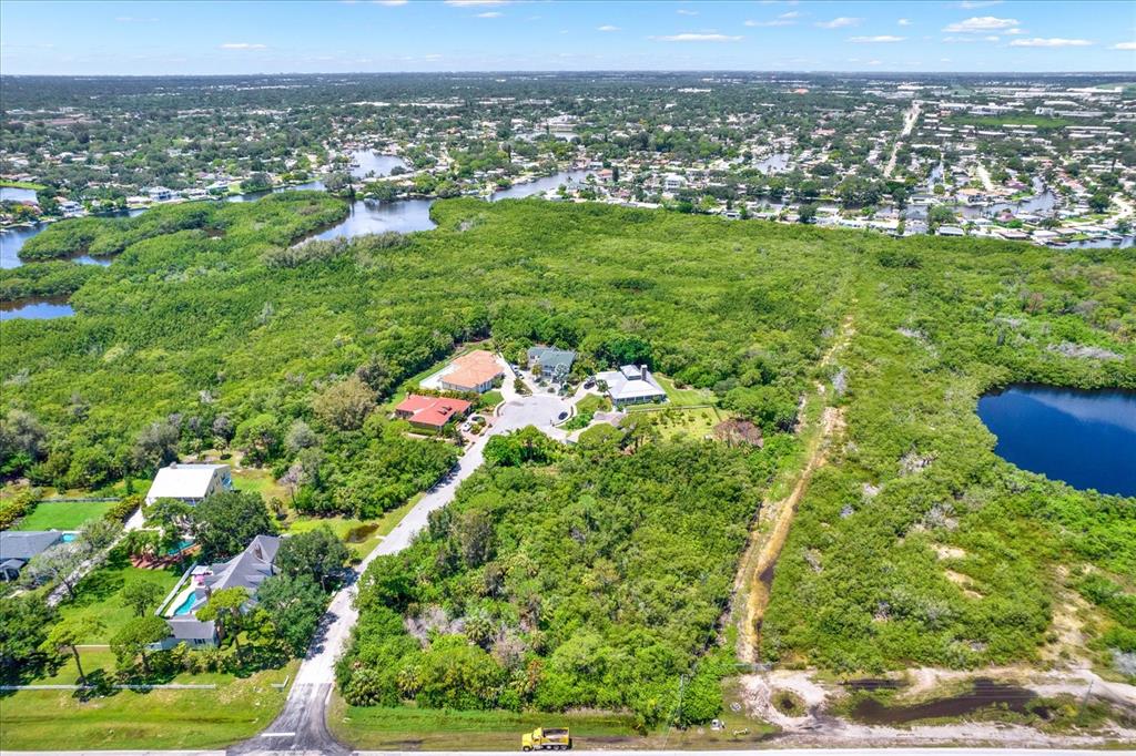 An aerial view shows a small residential cul-de-sac surrounded by dense forest and water bodies — OSCEOLA COURT NE, ST PETERSBURG, FL