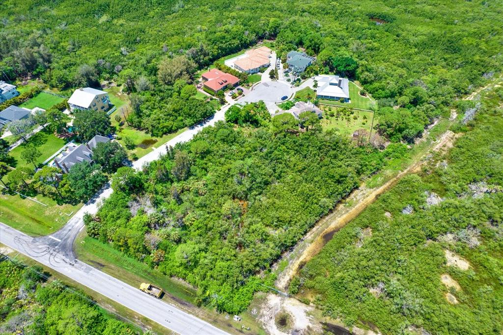 An aerial view shows a residential cul-de-sac surrounded by dense green vegetation and wetlands — OSCEOLA COURT NE, ST PETERSBURG, FL