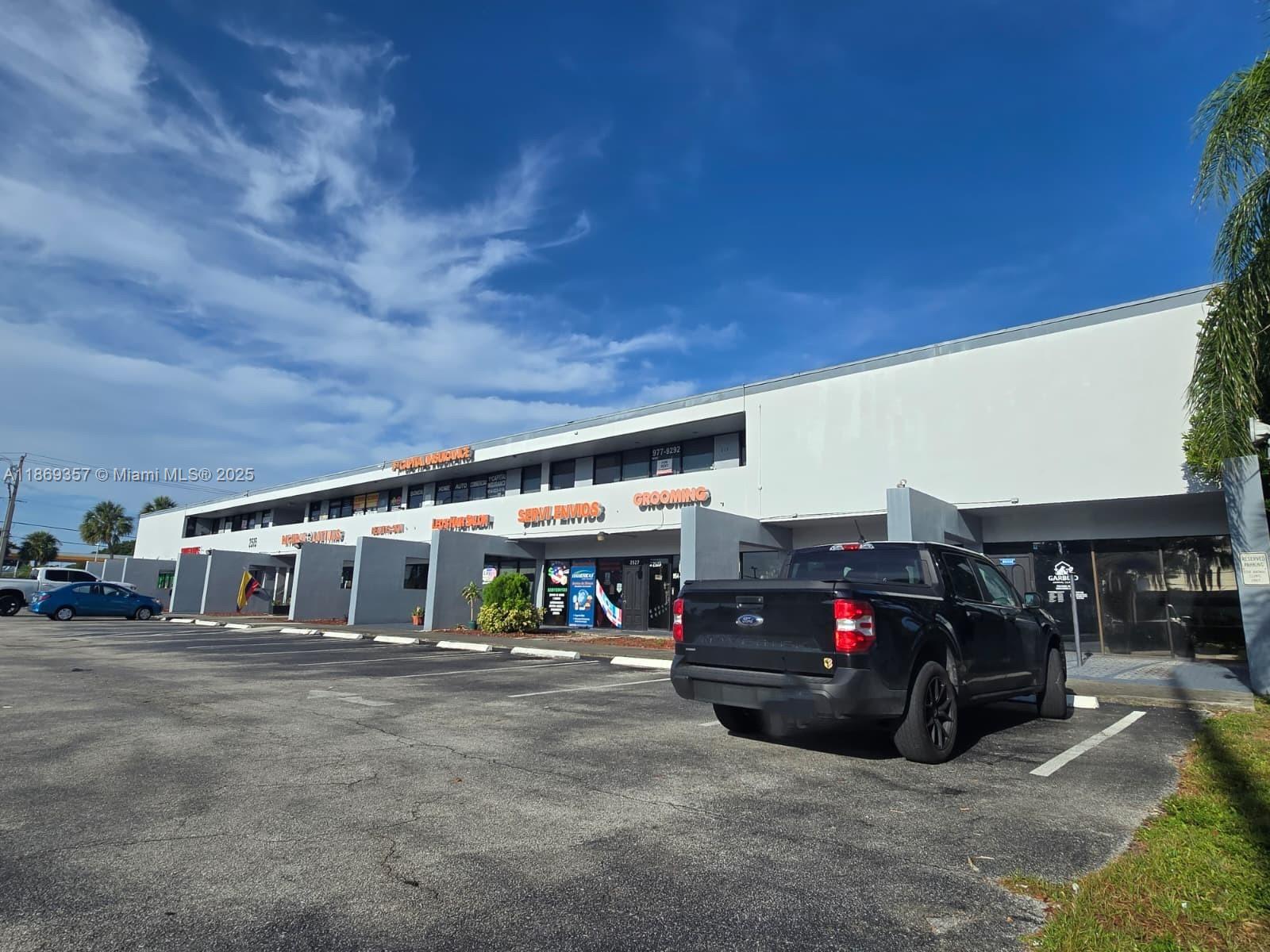 A black pickup truck is parked in front of a commercial strip mall building — 2501 N State Road 7 # 215, Margate FL 33063, MARGATE, FL
