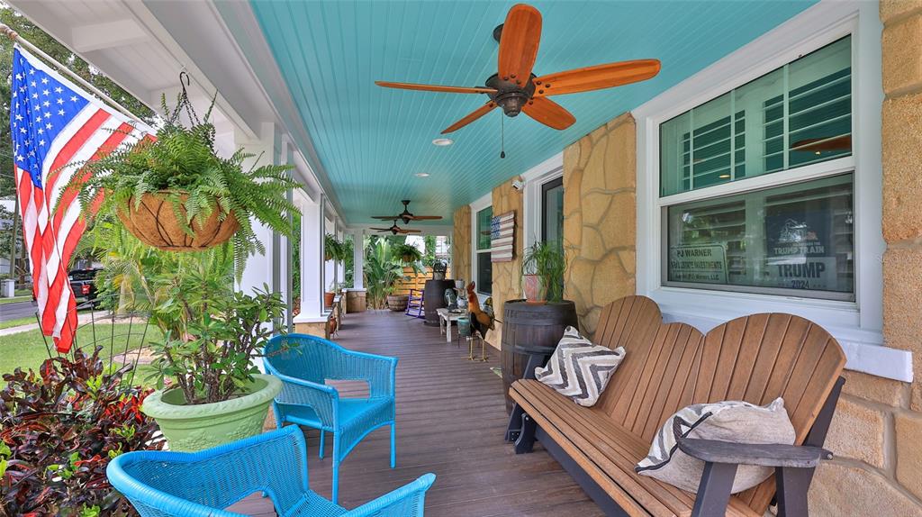 A covered front porch features a turquoise ceiling, wooden ceiling fans, and outdoor seating — 508 FAULKNER STREET, NEW SMYRNA BEACH, FL