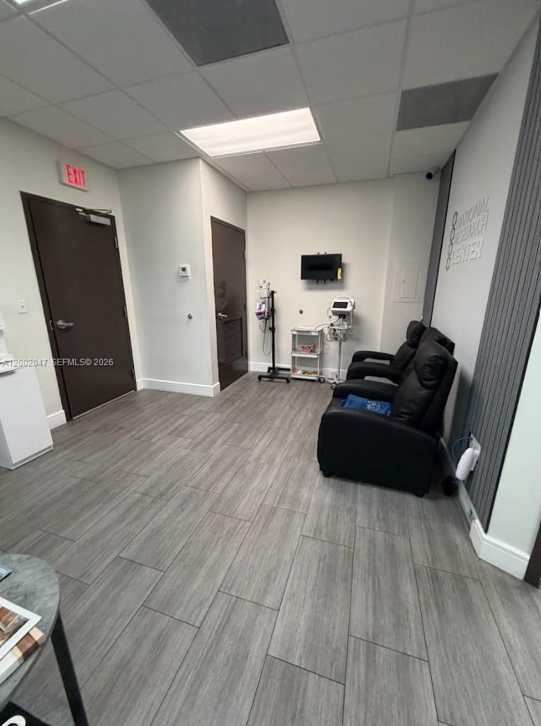 A medical office room features wood-look tile flooring, two black reclining chairs, and medical equipment — 8485 Bird Rd # 301, Miami FL 33155, MIAMI, FL