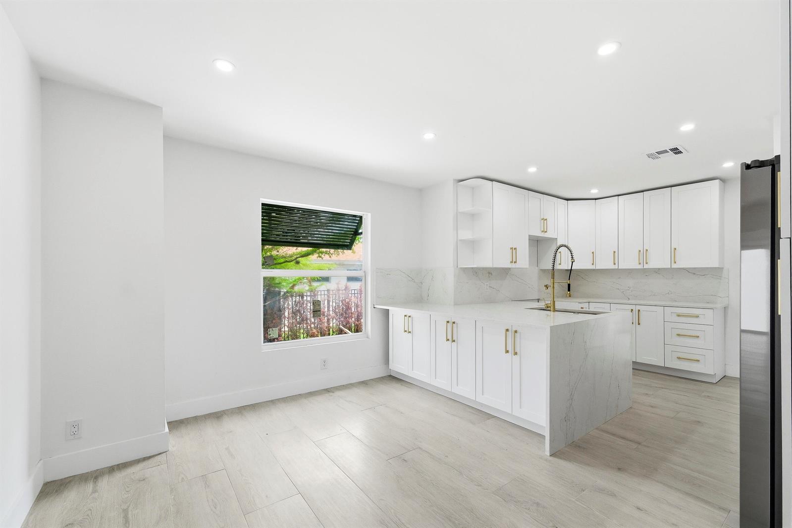 A yellow house with a gabled roof, a paved walkway, and green landscaping — 216 NE 23rd Avenue, Pompano Beach FL 33062, POMPANO BEACH, FL