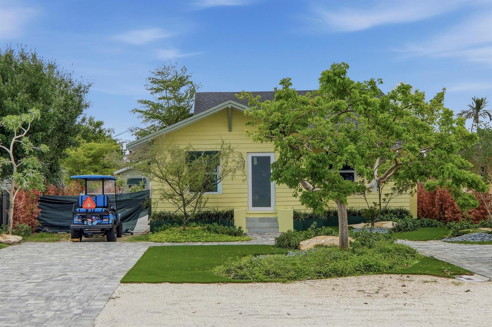 A modern kitchen features white cabinets, a marble-topped island, and light wood-look flooring — 216 NE 23rd Avenue, Pompano Beach FL 33062, POMPANO BEACH, FL