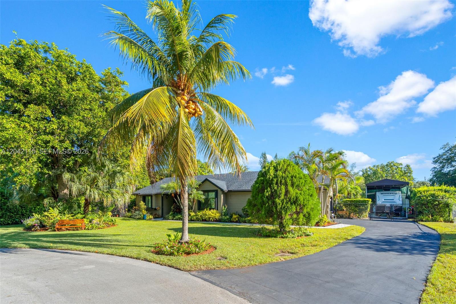 A single-story house with a palm tree, lawn, and driveway under a blue sky — 15031 SW 154th Ter, Miami FL 33187, MIAMI, FL