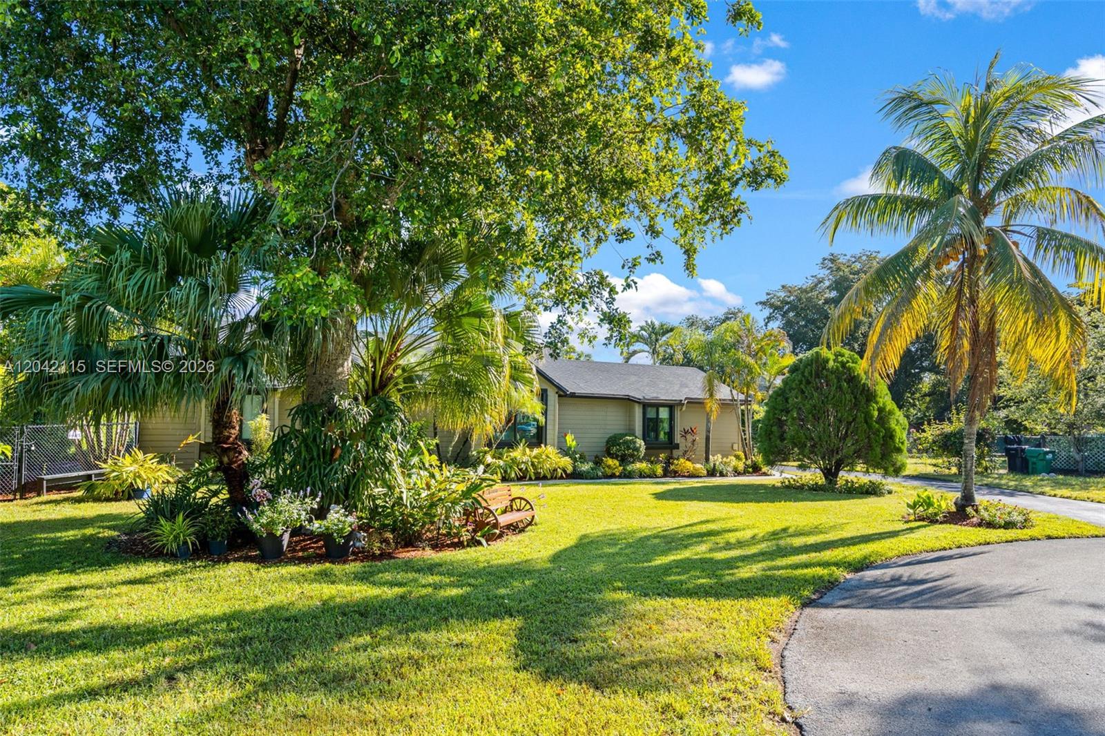 A single-story house with tan siding sits on a grassy lot with mature trees — 15031 SW 154th Ter, Miami FL 33187, MIAMI, FL