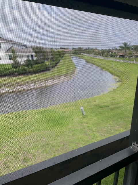 A view of a curved canal and grassy lawn seen through a screened-in porch — 5655 Via Delray Boulevard, Delray Beach FL 33484, DELRAY BEACH, FL