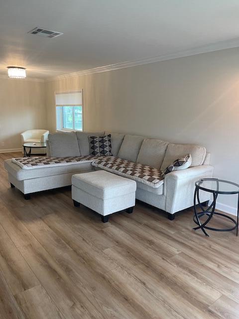 A living room features a light-colored sectional sofa, an ottoman, and wood-look flooring — 5655 Via Delray Boulevard, Delray Beach FL 33484, DELRAY BEACH, FL
