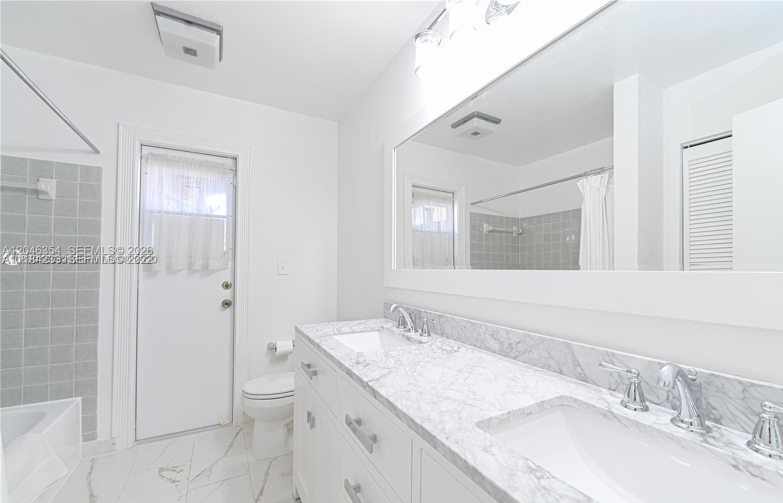 A bathroom features a double vanity with marble countertops, white cabinetry, and a walk-in shower — 9612 SW 117th Ave # 9612, Miami FL 33186, MIAMI, FL