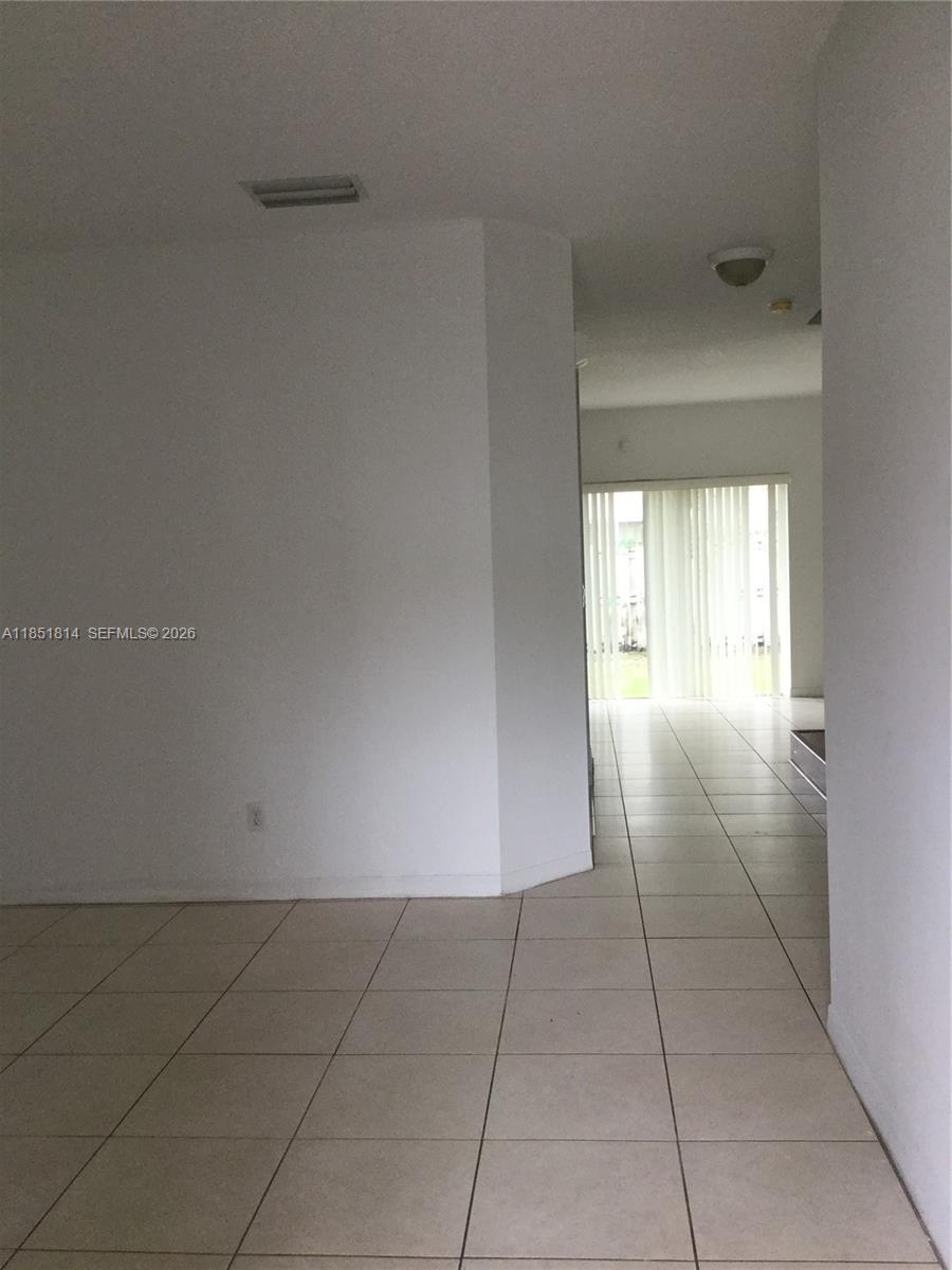 A tiled hallway leads toward a living area with vertical blinds and a sliding door — 2885 SW 127th Ave, Miramar FL 33027, MIRAMAR, FL