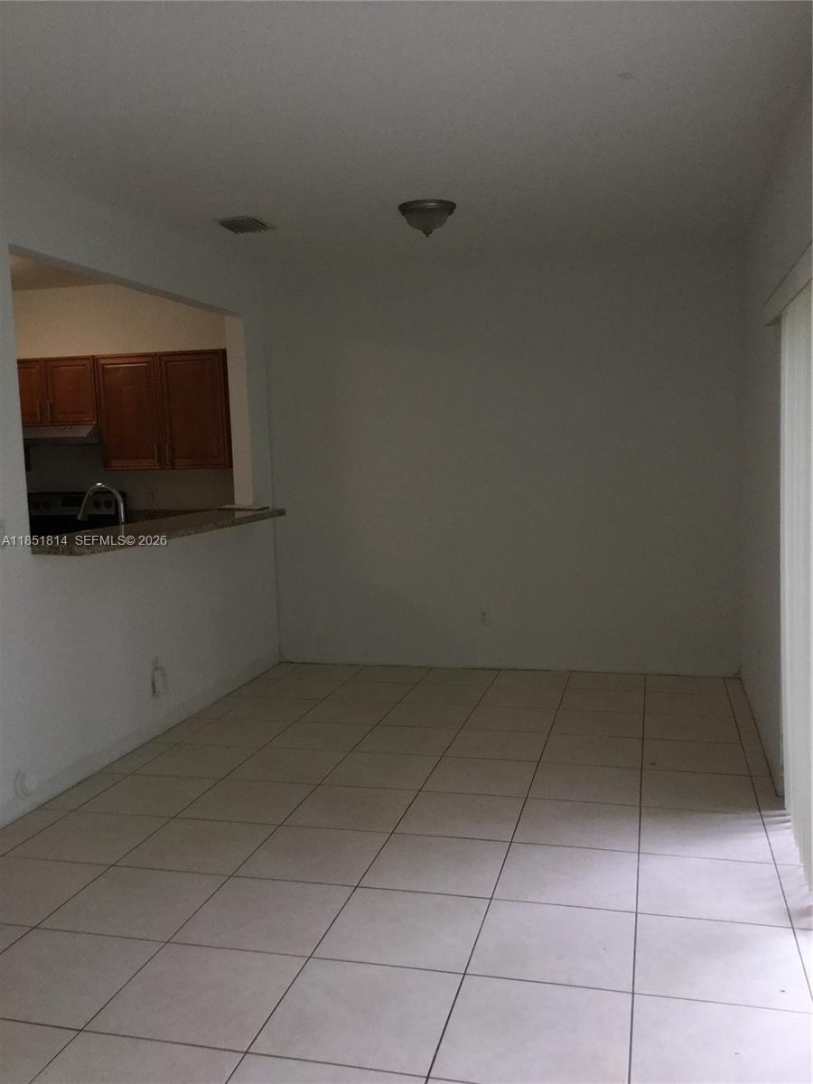 This room features light-colored floor tiles and an open pass-through window to the kitchen — 2885 SW 127th Ave, Miramar FL 33027, MIRAMAR, FL