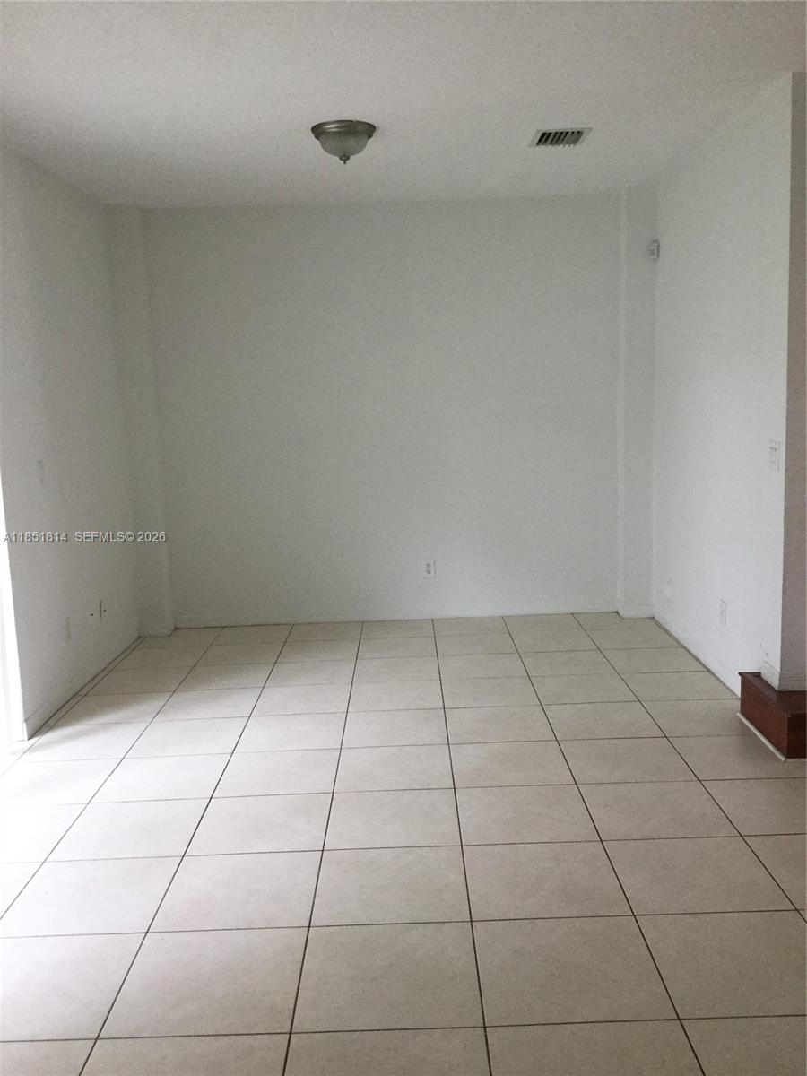 An empty room features white walls, a flush-mount ceiling light, and light-colored square floor tiles — 2885 SW 127th Ave, Miramar FL 33027, MIRAMAR, FL
