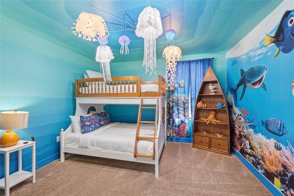 A bedroom with a bunk bed, jellyfish-themed ceiling lights, and a Finding Nemo wall mural — 1414 THUNDERBIRD ROAD, DAVENPORT, FL