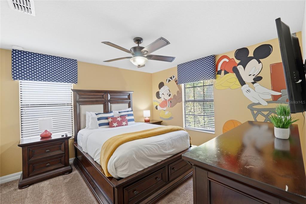 A bedroom features a bed, dark wood furniture, and a Mickey Mouse wall mural — 1414 THUNDERBIRD ROAD, DAVENPORT, FL