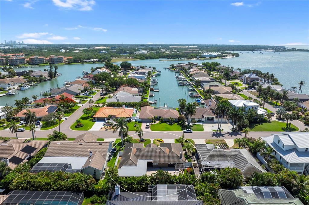 An outdoor kitchen features a granite-topped bar, stone base, wood-paneled ceiling, and stainless steel appliances — 6129 LEELAND STREET S, ST PETERSBURG, FL