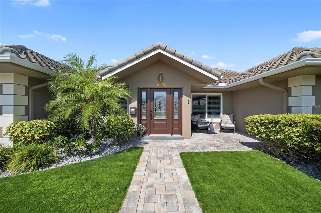 A backyard swimming pool with a spa, stone water feature, and covered patio area — 6129 LEELAND STREET S, ST PETERSBURG, FL