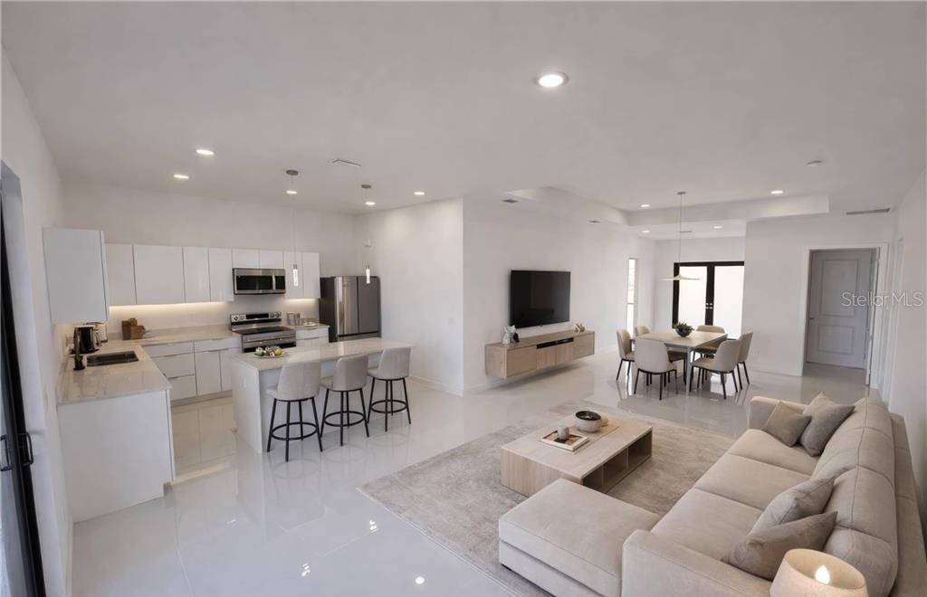 An open-concept kitchen, dining area, and living room with white cabinetry and light-colored tile floors — 2102 NW 25TH PLACE, CAPE CORAL, FL