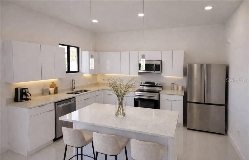 A modern kitchen features white cabinets, stainless steel appliances, and a central quartz-topped island — 2102 NW 25TH PLACE, CAPE CORAL, FL