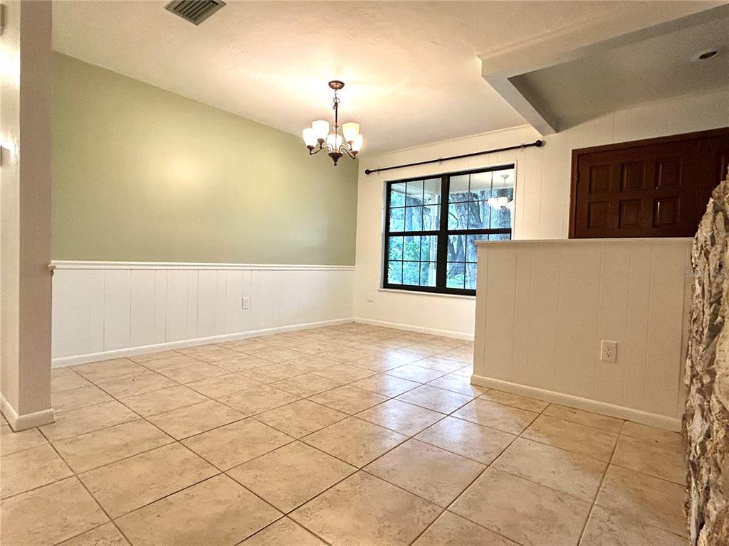 A kitchen features wood cabinets, granite countertops, stainless steel appliances, and light-colored tile flooring — 7532 SW 122ND STREET, GAINESVILLE, FL