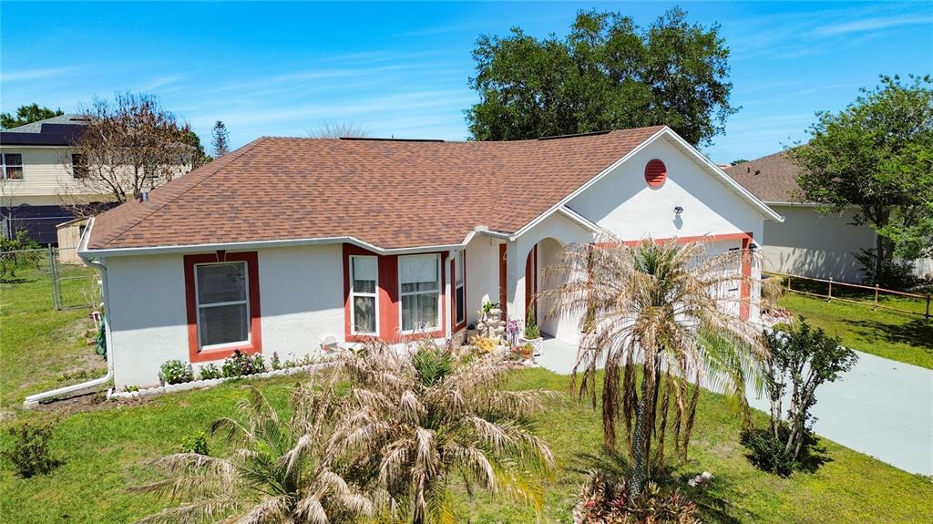 A single-story house with a brown shingled roof, white stucco walls, and red window trim — 852 FRANCONVILLE COURT, KISSIMMEE, FL