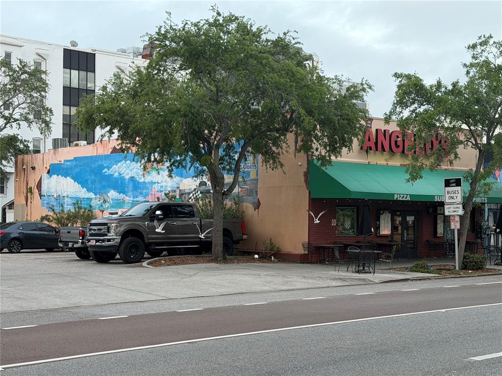 A street-level view of a commercial building with a mural and a green awning — 532 1ST AVENUE N, ST PETERSBURG, FL