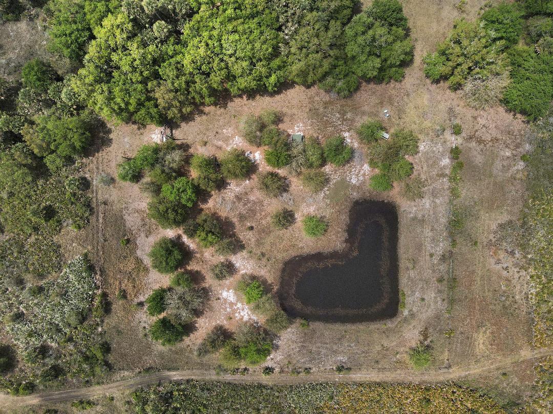 Aerial view of a rural property featuring a small pond and scattered trees — 0 NW 308th, Okeechobee FL 34972, OKEECHOBEE, FL