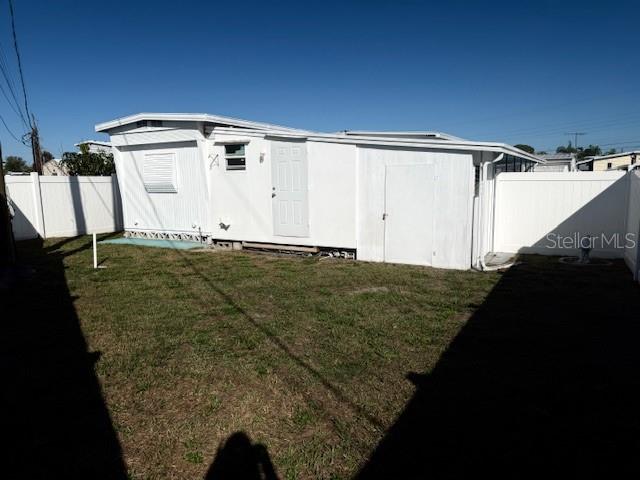 The exterior of a white mobile home features a side door and a small yard — 308 51ST AVENUE DRIVE W, BRADENTON, FL