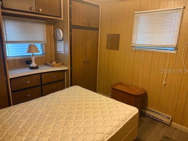 A bedroom features wood-paneled walls, a mattress, built-in storage cabinets, and a window with blinds — 308 51ST AVENUE DRIVE W, BRADENTON, FL