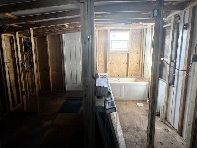 An unfinished room with exposed wall studs, a white bathtub, and a window — 308 51ST AVENUE DRIVE W, BRADENTON, FL