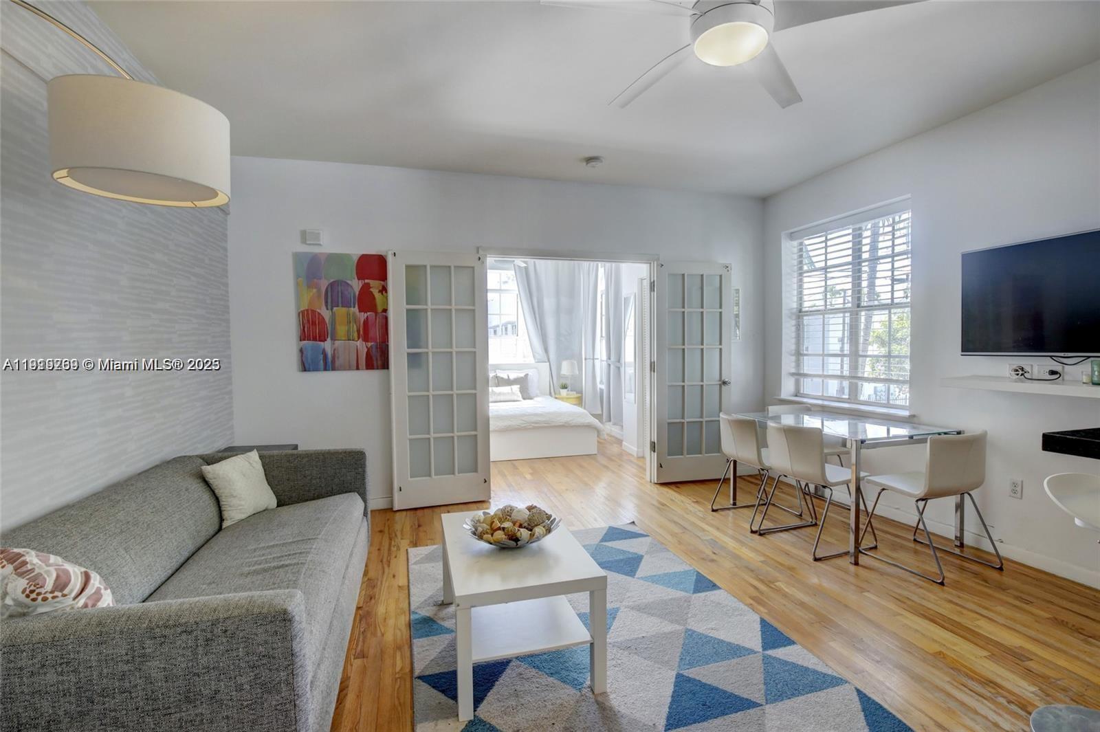 A living room features a gray sofa, a coffee table, and a dining area — 1127 Euclid Ave # 206, Miami Beach FL 33139, MIAMI BEACH, FL