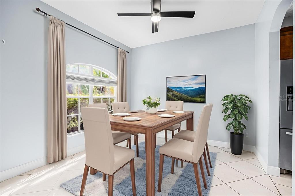 A dining room features a wooden table with six chairs, a ceiling fan, and curtains — 1892 HAMMOCK MOSS DRIVE, ORLANDO, FL