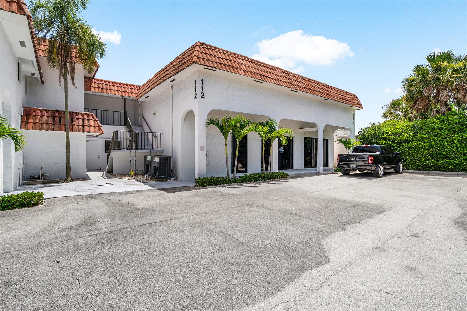 A two-story white commercial building with a terracotta tile roof and a paved parking lot — 112 N Us Highway 1, Tequesta FL 33469, TEQUESTA, FL