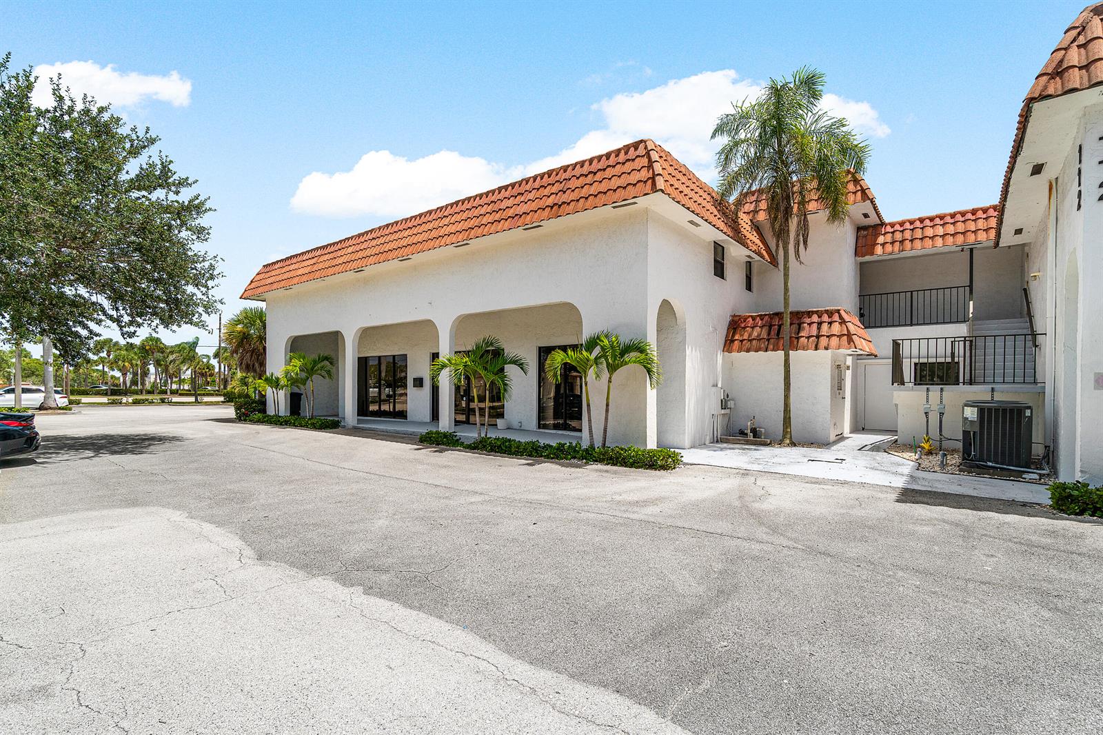 A white commercial building features a red tile roof, arched entryways, and small palm trees — 112 N Us Highway 1, Tequesta FL 33469, TEQUESTA, FL
