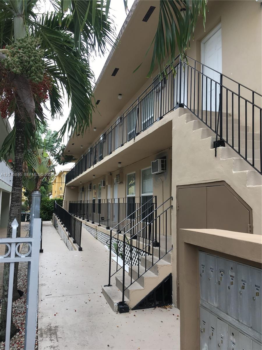 An exterior view of a two-story apartment building with a concrete walkway and metal railings — 960 Biarritz Dr # 2, Miami Beach FL 33141, MIAMI BEACH, FL