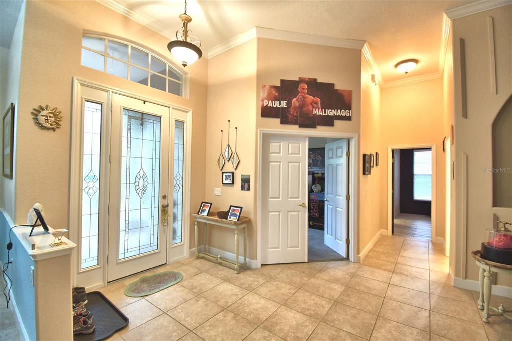 An entryway features tile flooring, a double-door front entrance, and a multi-panel wall art display — 1 LAKE ELOISE LANE, WINTER HAVEN, FL