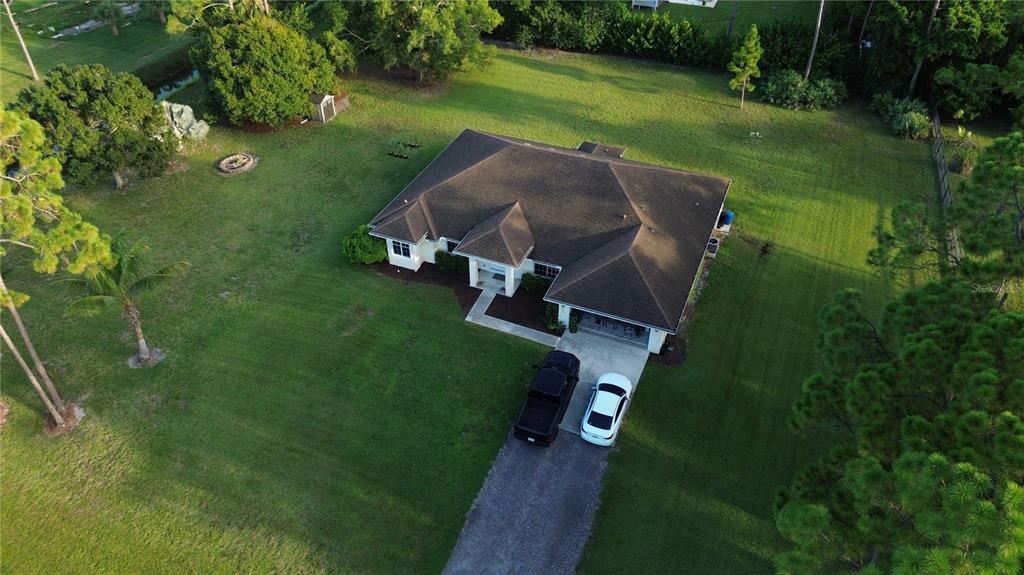 An aerial view of a single-story house with a dark roof, driveway, and large lawn — 17770 64TH PLACE N, LOXAHATCHEE, FL