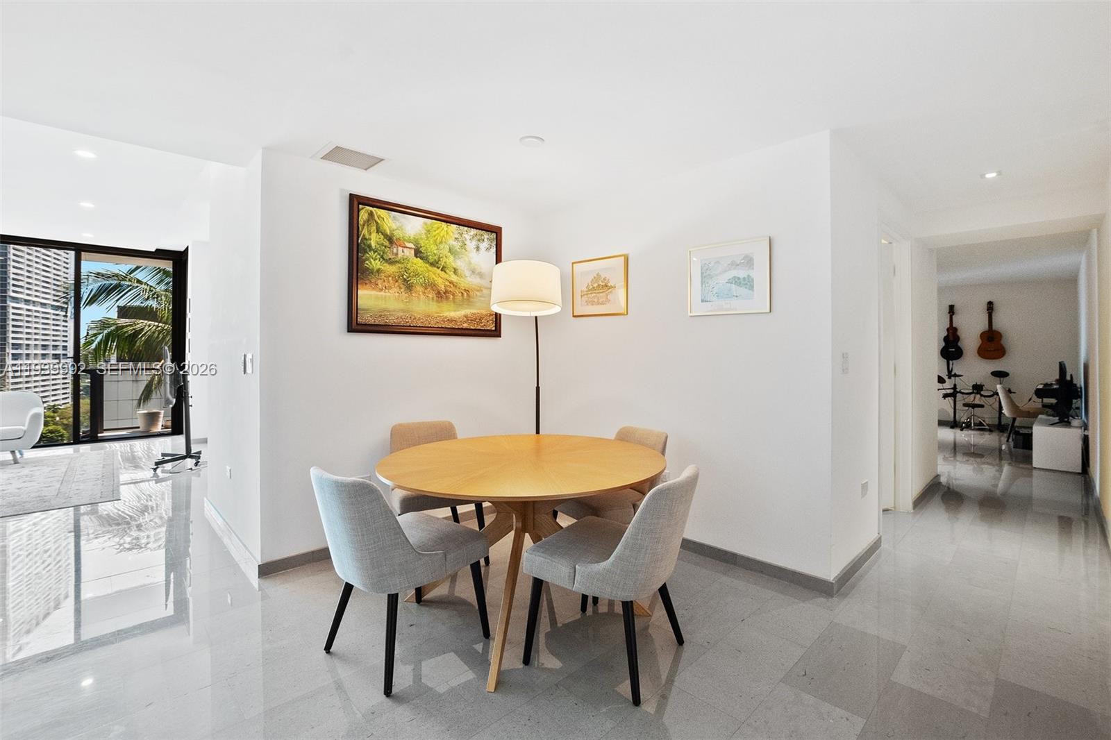 A dining area features a round wooden table, four chairs, and a floor lamp — 68 SE 6th Street # 805, Miami FL 33131, MIAMI, FL