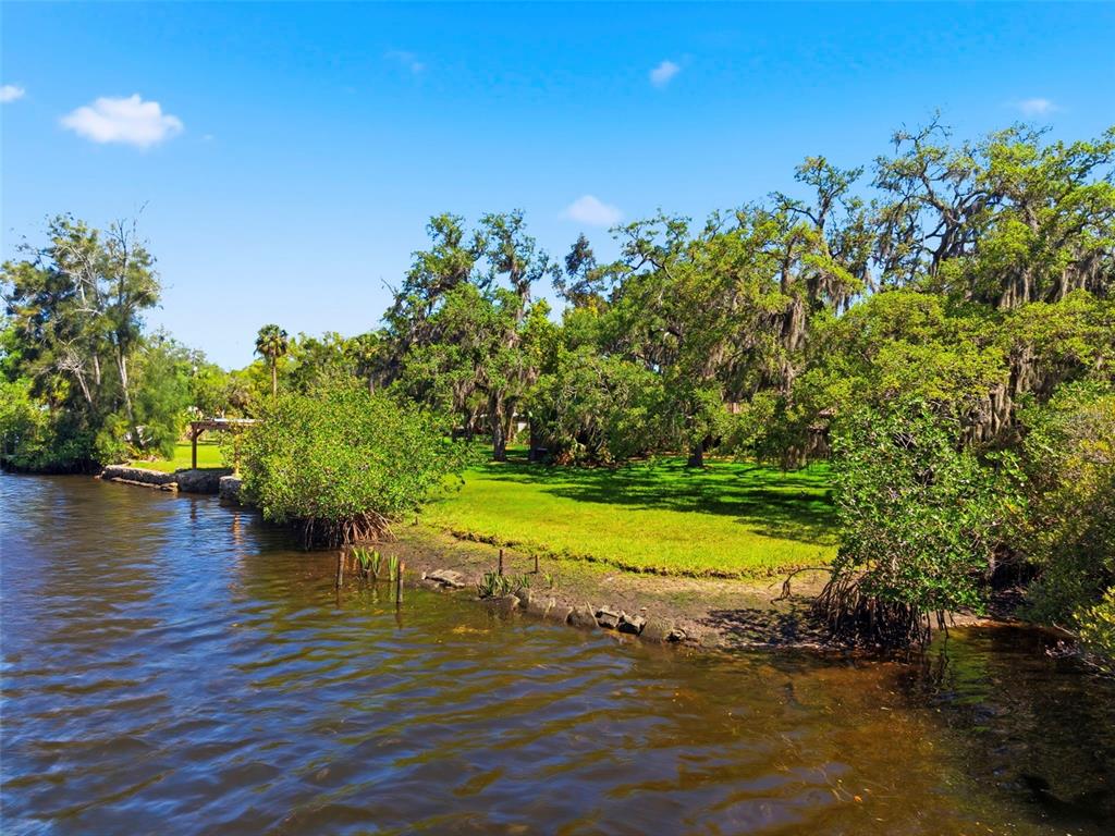 A grassy lawn meets a body of water with mangrove trees and large oak trees — 5651 MONROE STREET, NEW PORT RICHEY, FL