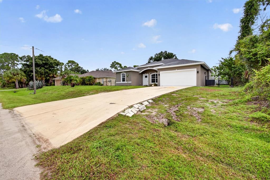 A single-story house with a white garage door and a concrete driveway — 1146 WOODCREST LANE, NORTH PORT, FL