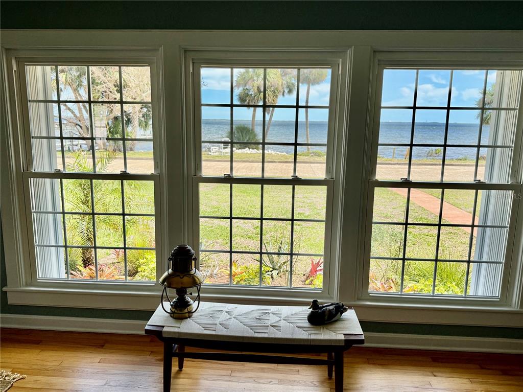 A room with three large windows overlooking a lawn and a body of water — 1322 RIVERSIDE DRIVE, TITUSVILLE, FL