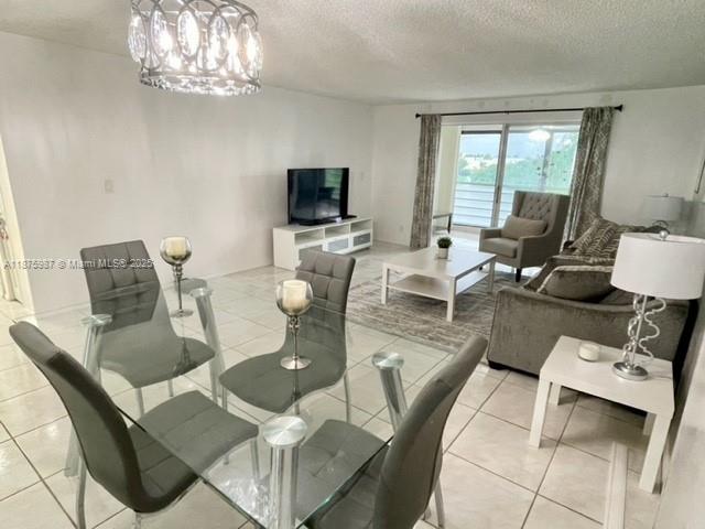 A dining area with a glass table and gray chairs opens into a living room — 131 SE 3rd Ave # 305, Dania Beach FL 33004, DANIA BEACH, FL