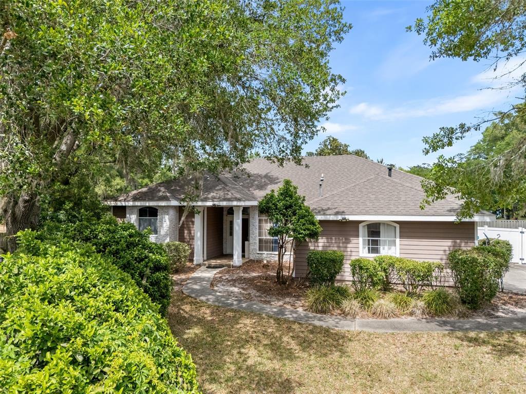 A single-story house with brown siding, a gray shingled roof, and a front walkway — 11520 NW 8TH LANE, GAINESVILLE, FL