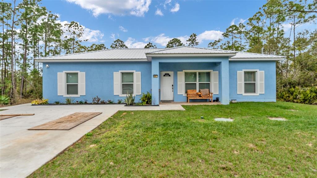 A single-story blue house with a white metal roof and a front porch — 6503 BURKETT AVENUE, SEBRING, FL