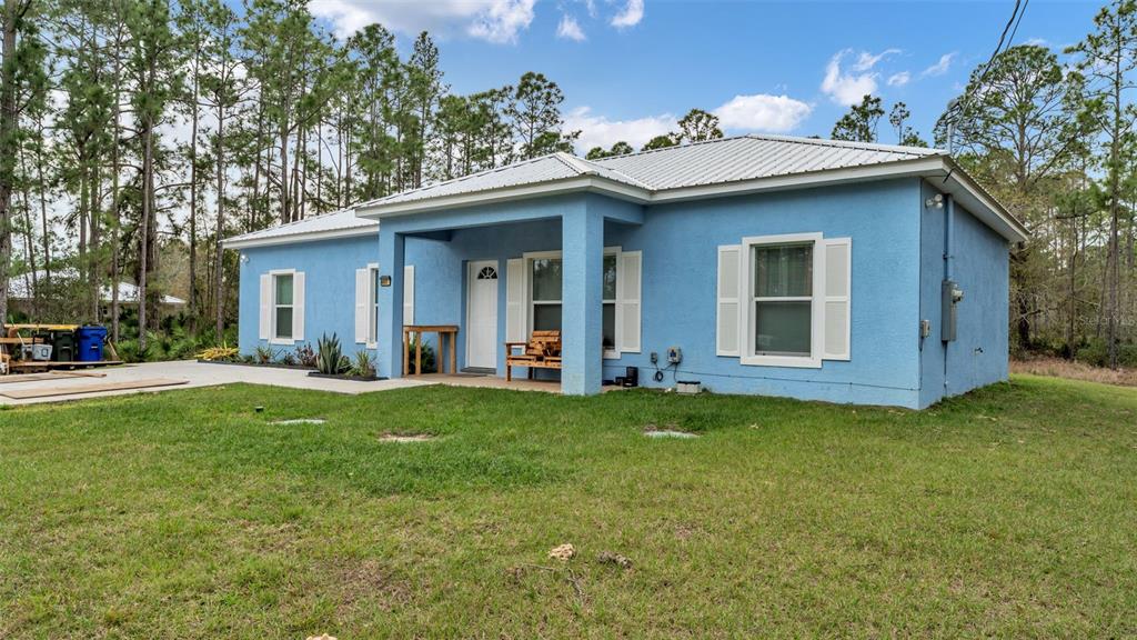 A light blue, single-story house with a metal roof and a covered front porch — 6503 BURKETT AVENUE, SEBRING, FL