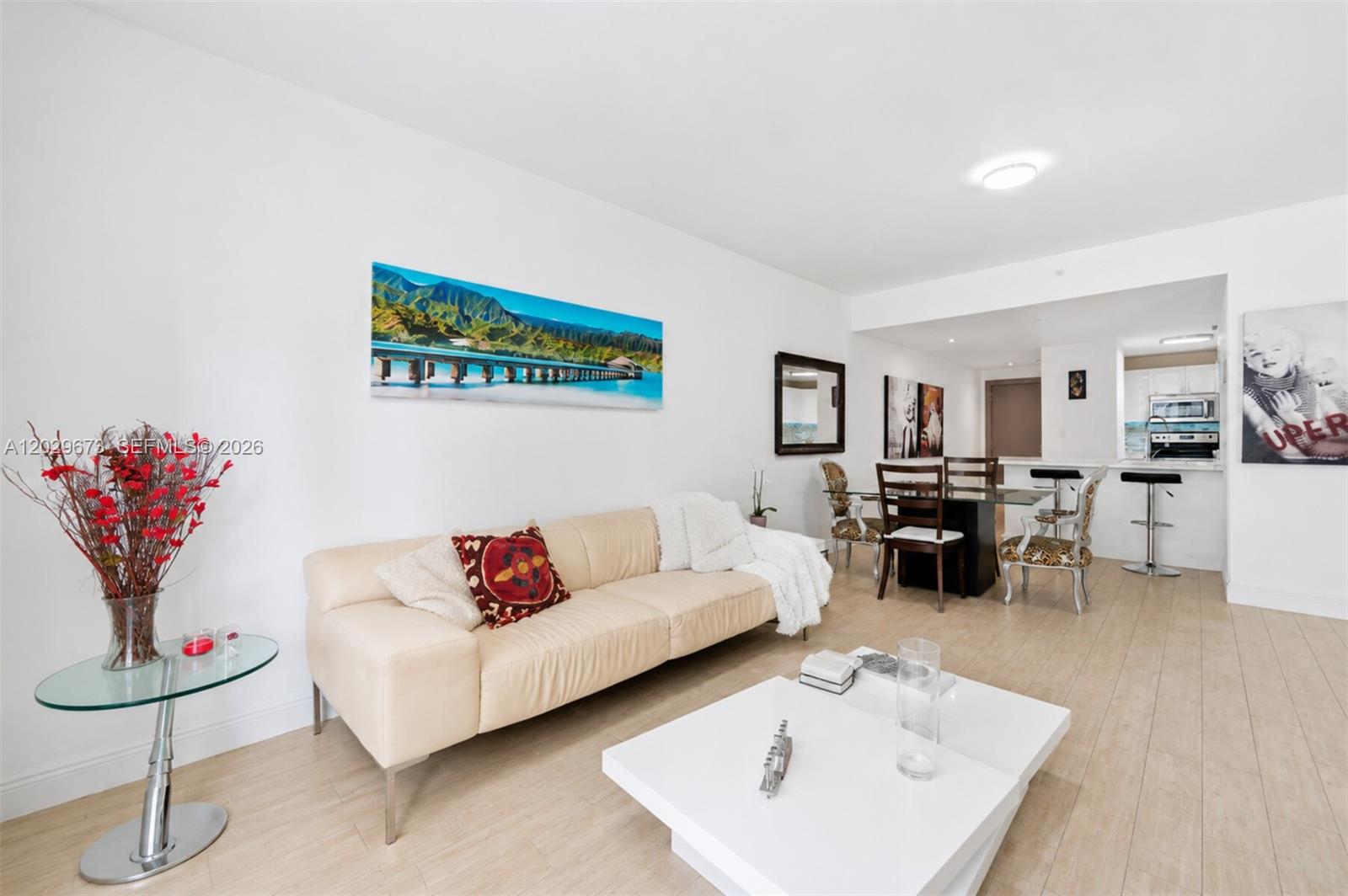 A living and dining area features a beige sofa, white coffee table, and tile flooring — 185 SE 14th Ter # 1410, Miami FL 33131, MIAMI, FL