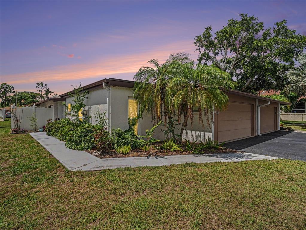 A single-story house exterior features a two-car garage, a palm tree, and a concrete walkway — 3506 AUBURN COURT UNIT 230, SARASOTA, FL