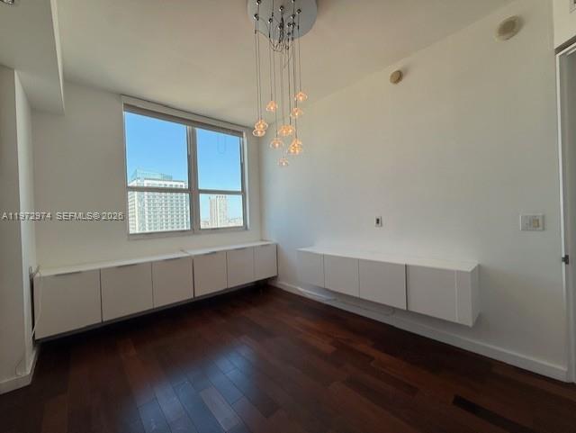 A room with dark wood floors, white wall-mounted cabinets, and a modern multi-pendant light fixture — 133 NE 2nd Ave # 3213, Miami FL 33132, MIAMI, FL