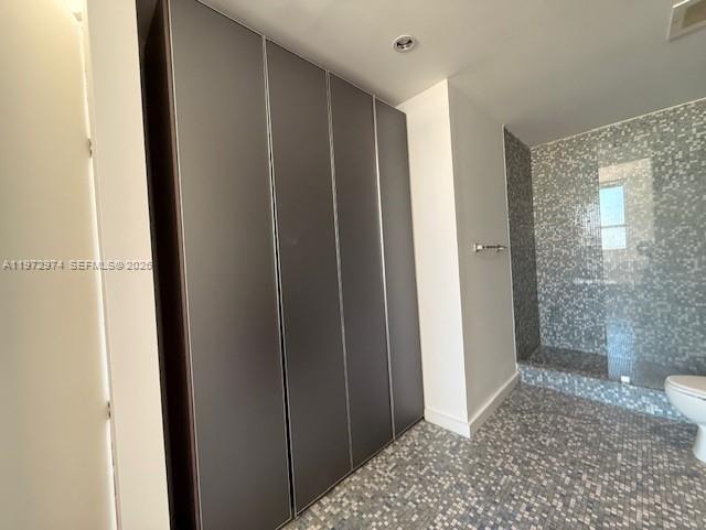 A bathroom features a tall dark cabinet, mosaic tile flooring, and a glass-enclosed shower — 133 NE 2nd Ave # 3213, Miami FL 33132, MIAMI, FL