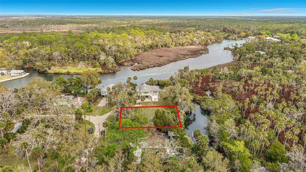 An aerial view shows a vacant, rectangular lot outlined in red near a river — 5360 FELKER DRIVE, WEEKI WACHEE, FL