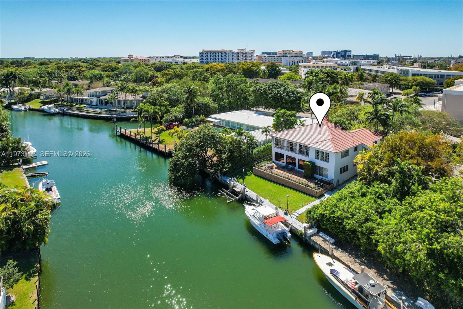 An aerial view shows a waterfront house with a red tile roof and boat docks — 1265 S Alhambra Cir # A, Coral Gables FL 33146, CORAL GABLES, FL